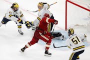 Denver’s Carter Savoie gathered the puck to score the winning goal on Michigan’s Erik Portillo in overtime during the first men’s Frozen Four se