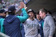 The Mariners’ Adam Frazier (26) celebrated with teammates in the dugout after scoring the go-ahead run in the top of the ninth inning in Seattle’s