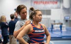 Assistant athletic trainer Anna Peterson helped Suni Lee remove an Olympic ring necklace at the beginning of an Auburn Tigers workout Friday, Dec. 17,