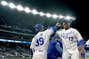 Kansas City Royals' Salvador Perez (13) celebrates with first base coach Damon Hollins after their baseball game against the Minnesota Twins Tuesday, 