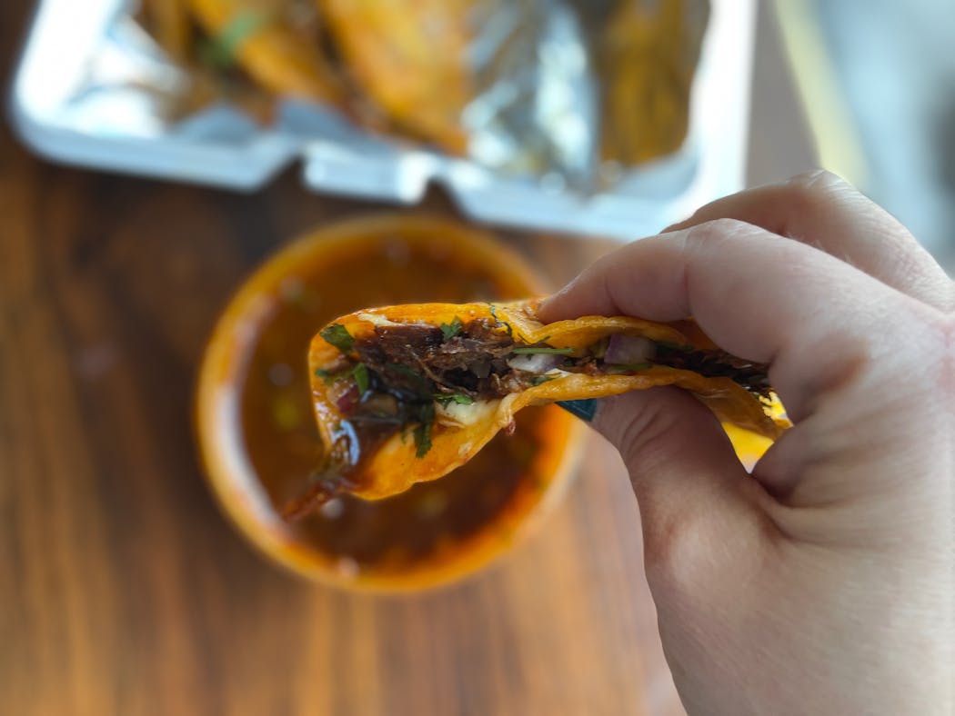 Juicy birria tacos come with a bowl of consommé.