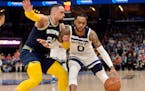 Timberwolves guard D’Angelo Russell drove on Grizzlies forward Dillon Brooks during Memphis’ win in Game 5 on Tuesday.