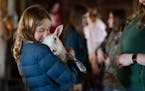 Colette Alexander, 12, snuggled up to a lamb she got to hold as the girls got a chance to get up close with the farm animals at the Girls Explore Scie