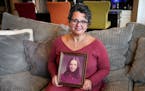 DeYanna Ostroushko with a photo of her mother, Debbie Nash Sedaghat, who died at age 24, just two weeks after DeYanna’s first birthday.