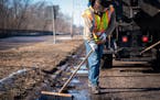 Street service worker Bradley Therres smooths asphalt over a pothole on Shepard Road in St. Paul on Friday, March 15, 2019.