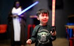 Riley Lynch, 4, plays with a lightsaber during the May the 4th be With You event Wednesday at Can Can Wonderland in St. Paul.