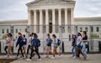 A high school tour group passed a new 8-foot fence outside the Supreme Court building in Washington. The fence was erected in preparation for expected