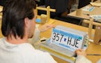 A prisoner inspects license plates produced at Rush City correctional facility north of the Twin Cities.
