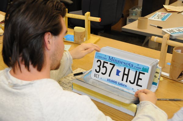 A prisoner inspects license plates produced at Rush City correctional facility north of the Twin Cities.
