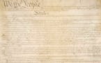 This photo made available by the U.S. National Archives shows a portion of the first page of the United States Constitution. 