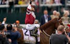 Sonny Leon, riding Rich Strike, celebrates after winning the 148th running of the Kentucky Derby 