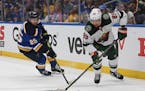 Wild winger Frederick Gaudreau worked the puck against the Blues’ Jordan Kyrou on Sunday in St. Louis.