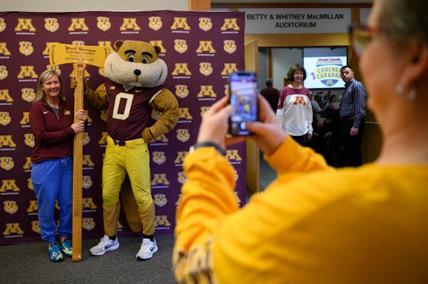 Jenni Morrison of White Bear Lake posed with Goldy Gopher and a rare visitor to Minnesota’s trophy case — Paul Bunyan’s Axe — during a Coaches