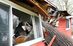 A tree toppled by high winds from a thunderstorm smashed into a house, splitting it in two Thursday in Coon Rapids. 