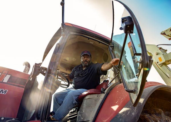 Farmer John Lee closes the door to his tractor before working in his field.