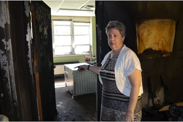 Debby Adams, administrator at Peace United Church of Christ, shows how a fire safety door stopped flames set on April 18, 2022, in the church’s lowe