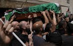 Mourners carry the Palestinian flag-draped coffin of slain Al Jazeera veteran journalist Shireen Abu Akleh on the way to her final resting place, in e