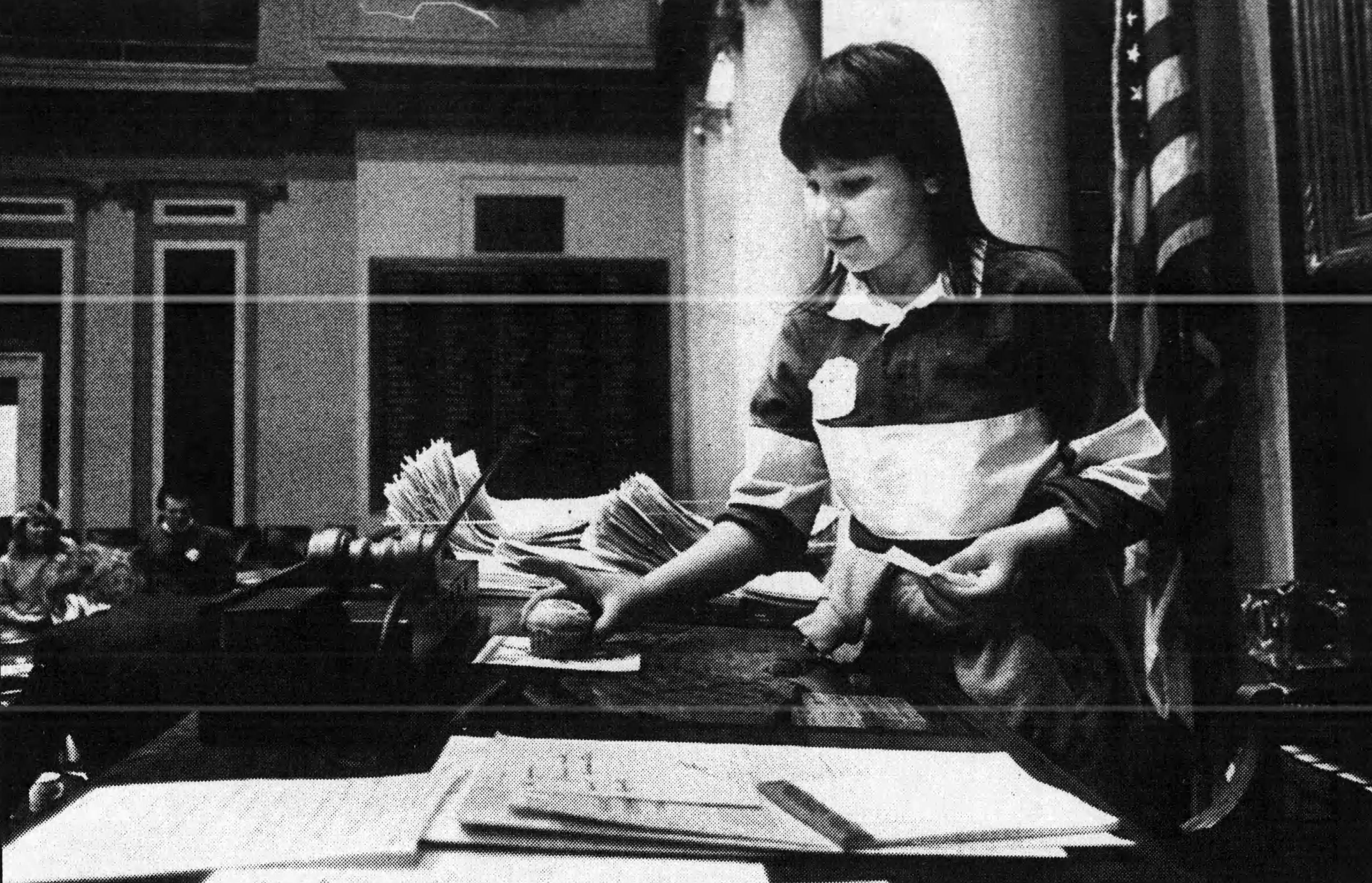 South Terrace Elementary student Jossette Martin placed a muffin on the desk of Speaker of the House Robert Vanasek in 1988. (This image is from a newspaper scan. The original version could not be located.)