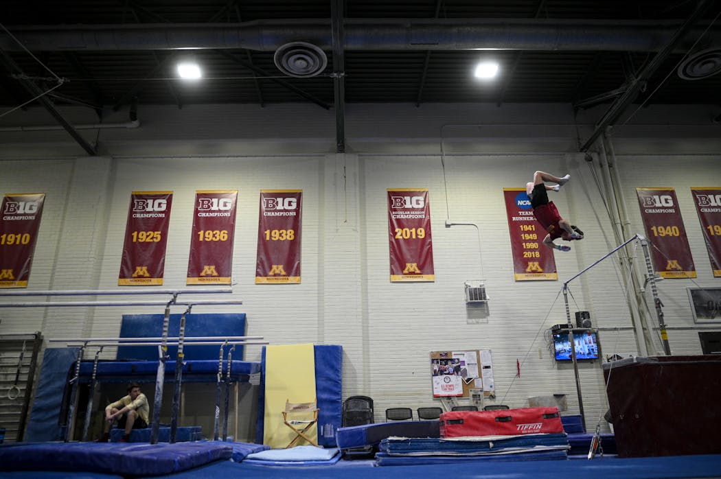 Minnesota freshman Kellen Ryan dismounted after practicing a high bar routine in April at Cooke Hall. The men’s gymnastics club team followed the same schedule they did as a varsity program.