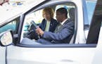Sen. Tina Smith and St. Paul Mayor Melvin Carter check out the interior of an Evie all-electric community rideshare vehicle, Friday, May 13, 2022 in S