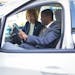 Sen. Tina Smith and St. Paul Mayor Melvin Carter check out the interior of an Evie all-electric community rideshare vehicle, Friday, May 13, 2022 in S