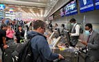 Delta ticketing agent Mohamed Abdi, right, helped a passenger check in at MSP’s Terminal 1 on Friday.