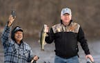 Gov. Tim Walz shows off the walleye he caught while Chairman Faron Jackson Sr. of the Leech Lake band of Ojibwe takes a video on his phone.