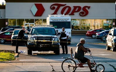 A cyclist on Sunday pauses outside a supermarket in Buffalo, N.Y., where a white, 18-year-old gunman fatally shot 10 people and wounded three others, 