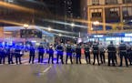 Chicago police block traffic near State and Monroe streets after crowds of young people flooded the Loop after a fatal shooting in Millennial Park in 