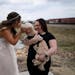 Bride Kelsey Goth gives her 1-year old Cockapoo Winston a kiss on the mouth as she’s held by professional pet attendant Maggie Van Remortel before G