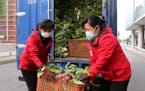 Employees of a greengrocery in Mirae Scientists Street carry cabbages to supply to residents staying home as the state increased measures to stop the 