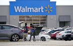 FILE - A Walmart employee helps a customer outside the Walmart store in Philadelphia, Wednesday, Nov. 17, 2021. Walmart reported stronger sales for th