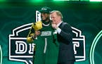 Florida State defensive end Jermaine Johnson II, left, and Roger Goodell, Commissioner of the NFL, hold a team jersey at the NFL draft.