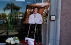 A photo of Dr. John Cheng, a 52-year-old victim who was killed in Sunday’s shooting at Geneva Presbyterian Church, is displayed outside his office i
