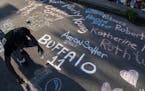 On May 15, Aaron Jordan, of Buffalo, adds to a sidewalk chalk mural depicting the names of the people killed in a mass shooting at Tops Friendly Marke