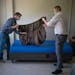 Steve Hoeppner, left, and Kevin Gronseth, volunteers at Catholic Charities, put sheets on beds in Minneapolis on Monday.