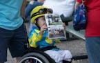 Austin Erickson, 6, (wearing his own jockey costume) shows off a special laminated program he got at the races with his family during opening night at