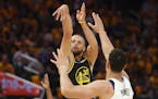 Golden State guard Stephen Curry watches his 3-point basket against Mavericks center Dwight Powell during the second half of Game 1 