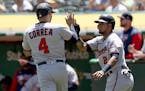 Minnesota Twins' Luis Arraez (2) congratulates Carlos Correa (4) after they score in the first inning of a baseball game in Oakland, Calif., on Wednes
