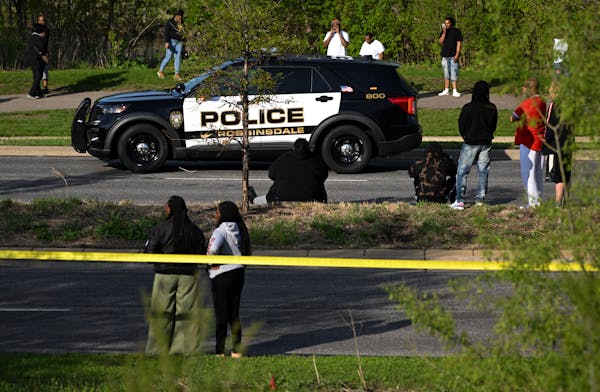 A crowd gathered near the scene of a fatal shooting in Robbinsdale on County Road 81 near Crystal Lake on Thursday.