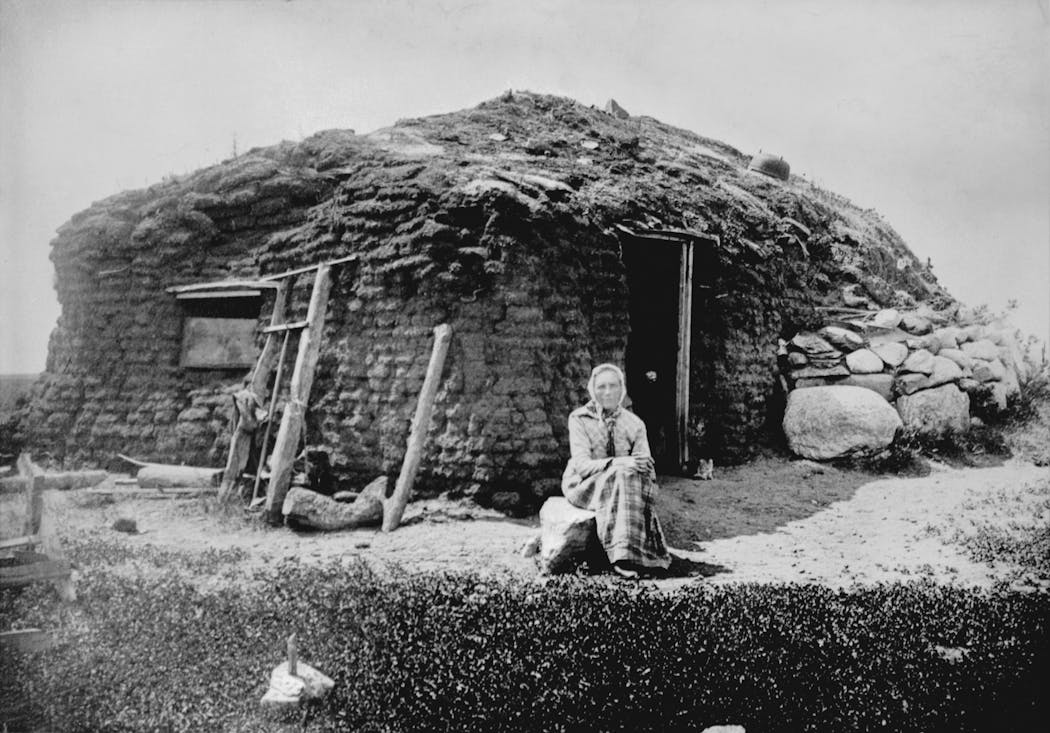 Norwegian immigrant Beret Hagebak in front of the sod home her family built in 1872 in western Minnesota. This photograph was taken in 1896.