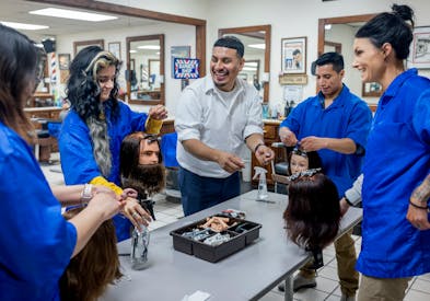 Barber Lamberto Vergara guided students on how to roll hair at the Minnesota School of Barbering in Minneapolis. After the riots destroyed the area wh