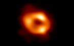 This is the first image of Sagittarius A*, the supermassive black hole at the center of our galaxy, with an added black background to fit wider screen