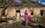 Iryna Martsyniuk, 50, stands next to her house, heavily damaged after a Russian bombing in Velyka Kostromka village, Ukraine, Thursday, May 19, 2022. 