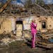Iryna Martsyniuk, 50, stands next to her house, heavily damaged after a Russian bombing in Velyka Kostromka village, Ukraine, Thursday, May 19, 2022. 