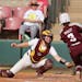 Gophers catcher Sara Kinch prepared to apply a tag on Texas A&M’s Koko Wooley during the sixth inning Friday in Norman, Okla.