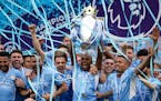 Manchester City players celebrate with trophy after winning the 2022 English Premier League title 