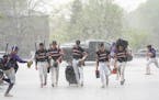 Cretin-Derham Hall baseball players ran behind Stillwater baseball players walking to their bus to find shelter at the school during a hailstorm on Th