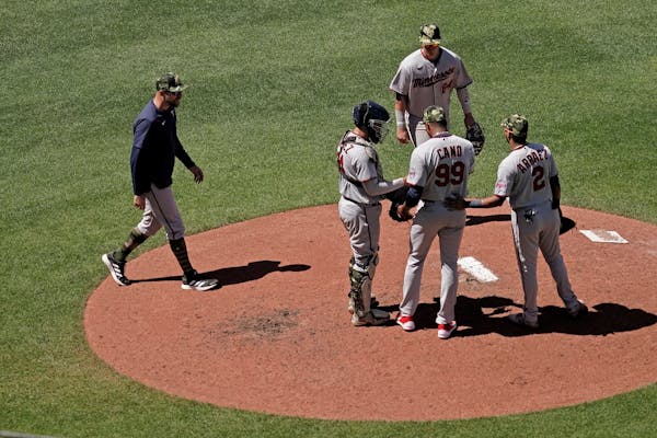 Twins manager Rocco Baldelli, left, walked to the mound to make a pitching change during the sixth inning Sunday, removing rookie Yennier Cano to brin