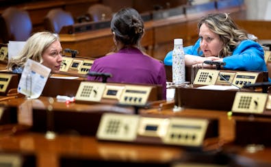 Rep. Heather Edelson and Rep. Emma Greenman spoke with another legislator in the House Chamber during a recess Sunday at the state Capitol. 